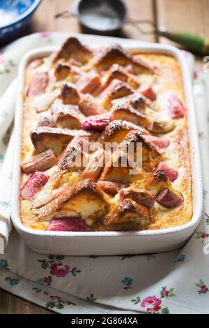 Rhubarb ricotta bread and butter pudding with icing sugar Stock Photo