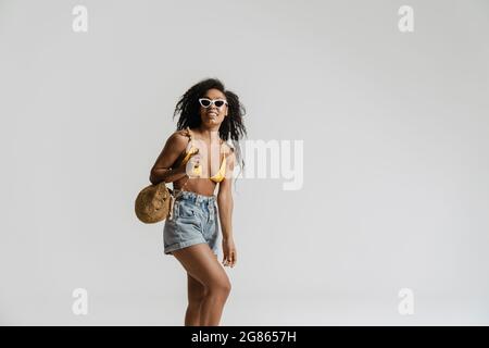 Black woman in swimsuit smiling while posing on camera isolated over white background Stock Photo