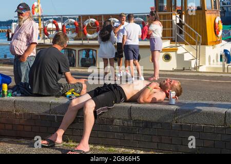 Visitors relaxing on in the evening Poole Quay at Poole Harbour, Poole, Dorset UK in July Stock Photo