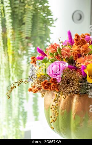 Floral arrangement of roses inside pumpkin decorated for a different Halloween Stock Photo