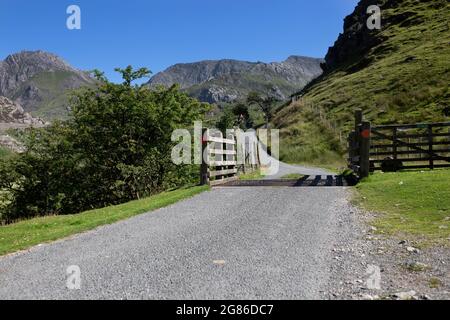 Cattle grid on a rural road in the Nant Ffrancon Valley part of the Snowdonia National Park, North Wales.  On a summers day with blue sky. Stock Photo