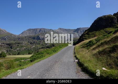 Rural road in the Nant Ffrancon Valley part of the Snowdonia National Park, North Wales.  On a summers day with blue sky. Stock Photo