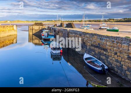 A lovely still morning with the fishing boats reflected in the harbour at Beadnell on the Northumberland coast, England. Stock Photo