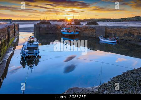 A colourful sunset at the small harbour at Beadnell, the only west-facing harbour on Northumberland's coast, England, Uk Stock Photo