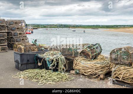 Lobster pots and rope lay by the harbourside at Amble in Northumberland, England. Stock Photo