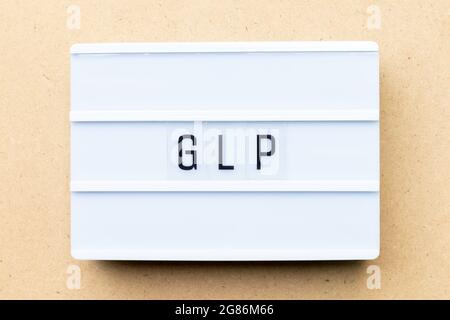 White lightbox with word GLP (Abbreviation of Good laboratory practice) on wood background Stock Photo