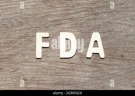 Alphabet letter in word FDA (abbreviation of food and drug administration) on wood background Stock Photo