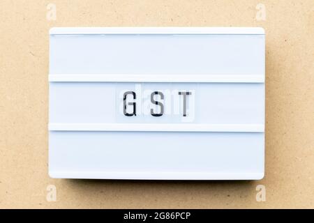 White lightbox with word GST (Abbreviation of Goods and Service Tax) on wood background Stock Photo
