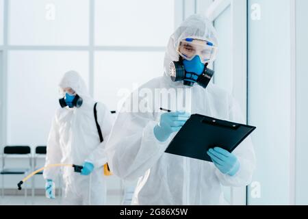 employee of the sanitary service making an entry in the clipboard. Stock Photo