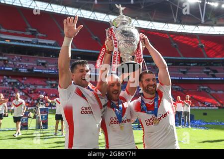 James Roby (9), Kyle Amor (16) and Louie McCarthy-Scarsbrook (15) of St Helens celebrate with the cup Stock Photo