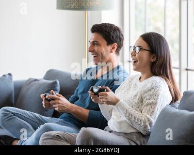 Joyful Asian Boyfriend And Girlfriend Playing Video Game At Home