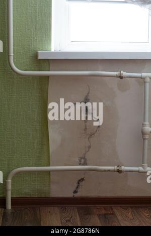 Crack in the wall of the apartment. Rain water flows into the apartment through a crack in the wall. Stock Photo