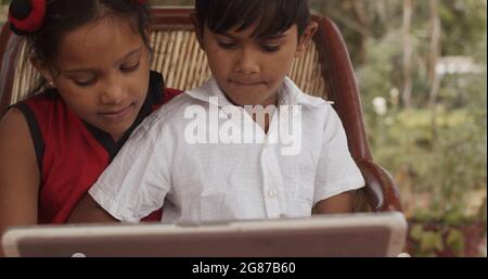 Absorbed  Indian kids are using a laptop or tablet Stock Photo