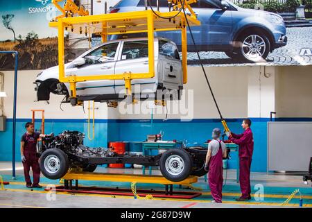 Kostanay,Kazakhstan,May14,2012:Saryarkaavtoprom auto-building plant.Ssangyong cars assembling.Connecting car body and chassis with manipulator Stock Photo