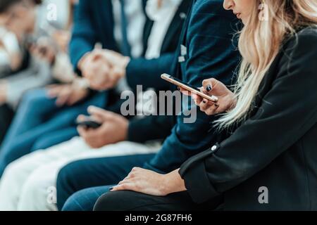 background image of a group of young people sitting in a queue Stock Photo