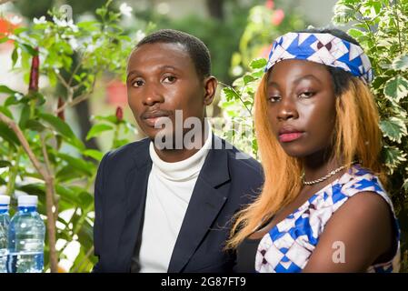 Happy young couple sitting at table outside in front of two bottle having a date in a cafe during the summer Stock Photo