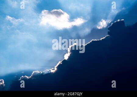 sunbeams behind a dark cloud Stock Photo