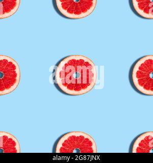 Grapefruit seamless pattern on a blue background. Tropical abstract background. Fruit texture. Top view, flat lay. Stock Photo