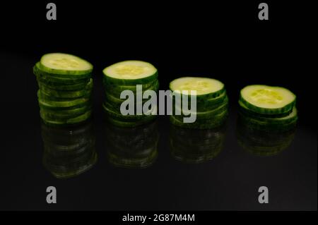 Stack of cucumber slices on an isolated black background Stock Photo