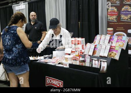 Houma, USA. 17th July, 2021. A seller serves sample food during the annual Bayou Home Show and Cannata's Festival of Food in Houma, Louisiana, the United States, on July 17, 2021. The home show and festival of food is held on Saturday and Sunday in Houma, showcasing the latest products and services in kitchens, bathrooms, siding and solar products. Credit: Lan Wei/Xinhua/Alamy Live News Stock Photo