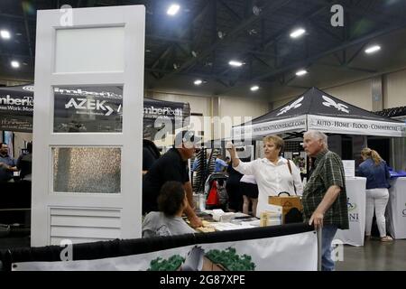 Houma, USA. 17th July, 2021. Visitors talk to an exhibitor during the annual Bayou Home Show and Cannata's Festival of Food in Houma, Louisiana, the United States, on July 17, 2021. The home show and festival of food is held on Saturday and Sunday in Houma, showcasing the latest products and services in kitchens, bathrooms, siding and solar products. Credit: Lan Wei/Xinhua/Alamy Live News Stock Photo