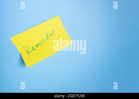 Yellow adhesive note on blue light background. Minimalist concept. Copy-space Stock Photo