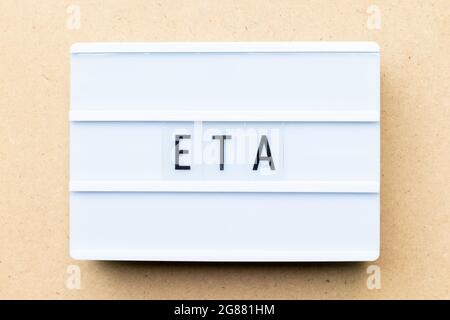 White lightbox with word ETA (abbreviation of Estimated time of arrival) on wood background Stock Photo