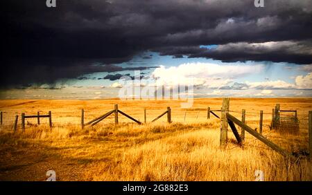 dark clouds over prairie field Stock Photo