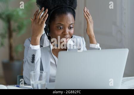 Angry woman worker in headphones microphone talk to client in call center office with frustration Stock Photo