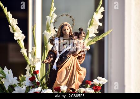 A view of a statue of the Virgen del Carmen during the seafaring procession in Vendrell. Every year on July 16 a religious festival is celebrated in honor of the Virgen del Carmen, patron saint of sailors and fishermen, although the celebration is on July 16, the procession is held on the weekend so that more people can attend the celebration. The statue of Virgin, is carried by a group of people taking it to a boat leaving during the procession through the waters of the sea near the port followed by several boats. (Photo by Ramon Costa/SOPA Images/Sipa USA) Stock Photo