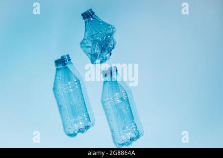 Used empty crumpled plastic bottles on blue background. Recycling recycled plastic. Pollution, environmental protection. Stock Photo