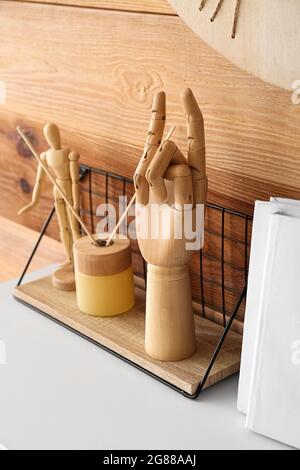 Wooden hand, books and decor on table Stock Photo