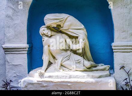 Pieta Mary Jesus Statue White Abobe Garden Shrine Mission San Diego de Alcala California.  Founded in 1769 by Junipero Serra, first mission in Califor Stock Photo