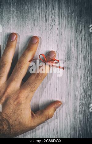 Red String Tied Around a Finger. Memory and Reminder Knot. Stock Photo