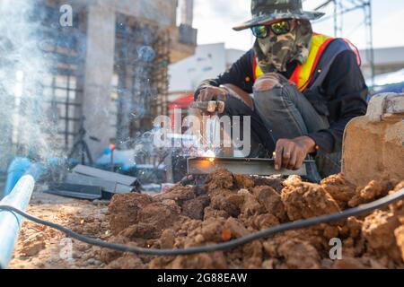 Welding worker man in the construction site in uniform safety Stock Photo