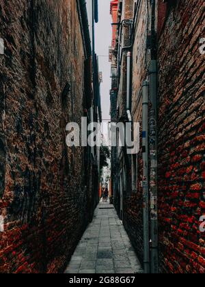 A vertical shot of a narrow street in the medieval village of ...