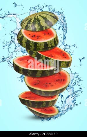 Ripe watermelon cut into pieces flying in the air. Floating, flying, levitating sliced fresh watermelon with splash of water on a blue background. Cre Stock Photo