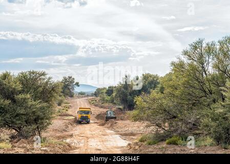 VONDELING, SOUTH AFRICA - APRIL 21, 2021: A frontloader, clearing sand from a causeway in the Traka River on road R407 between Klaarstroom and Willowm Stock Photo