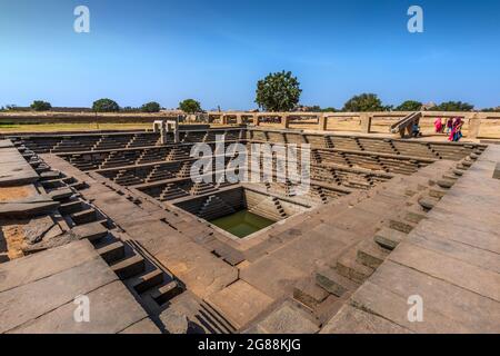 Hampi, Karnataka, India - January 14, 2020 : Symmetrical stepped square water tank (Stepwell) inside the Royal Enclosure at Hampi. Stock Photo