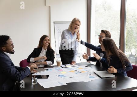 Happy mature mentor giving high five to Stock Photo