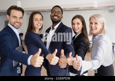 Happy multiethnic different aged business team making thumbs up Stock Photo