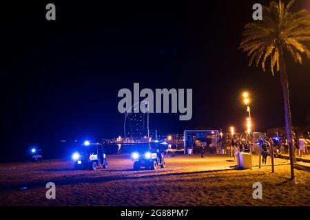 Catalan police is seen vacating the young people partying and making spontaneus drinking gatherings, known as botellones "botellones",  in the Barceloneta beach in Barcelona, Spain on July 18, 2021. The catalan government ordered a new curfew from 00.30 till 6.00am  after a surge in the contagion rate, especially among young unvaccinated people, due also to the spread of the new delta variant. The new restrictions are expected to hit the hospitality industry and curb its hopes to recover after more than a year of closure, as they only leave the possibility to use outdoors terraces and forbid i Stock Photo