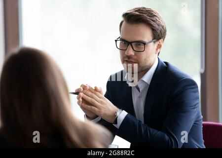 Serious male manager, lawyer, broker, talking to client, giving consultation Stock Photo