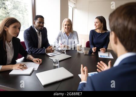 Mentor, coach talking to employees, giving training, discussing marketing reports Stock Photo