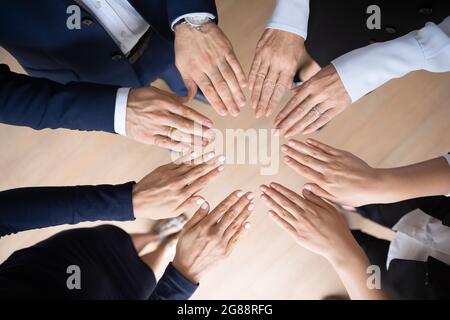 Different aged business team making circular shape of hands Stock Photo