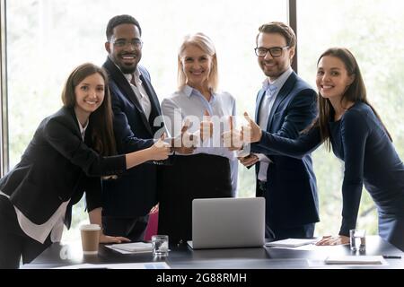 Happy diverse business team making thumbs up gesture Stock Photo