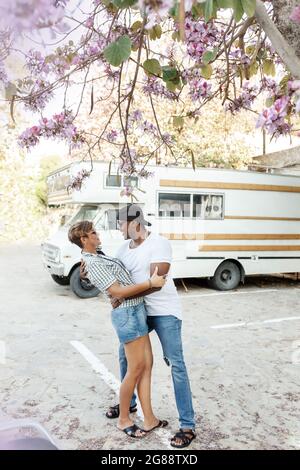 Multicultural african and latin couple enjoing traveling together .middle age mixed race, multi-ethnic couple on vacation in Europe. Trailer car on ba Stock Photo