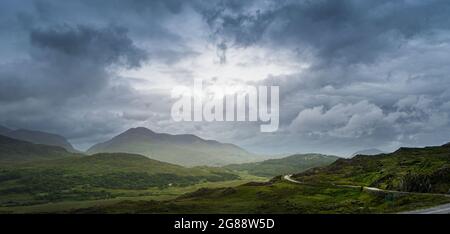 Panoramic view of Irish landscape from Ladies View in Killarney National Park, with a sky with very dense clouds. Stock Photo