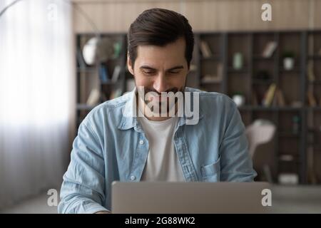 Happy young caucasian man working on computer. Stock Photo