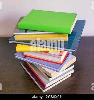 Stack of colorful  books on dark table. Free space for text Stock Photo